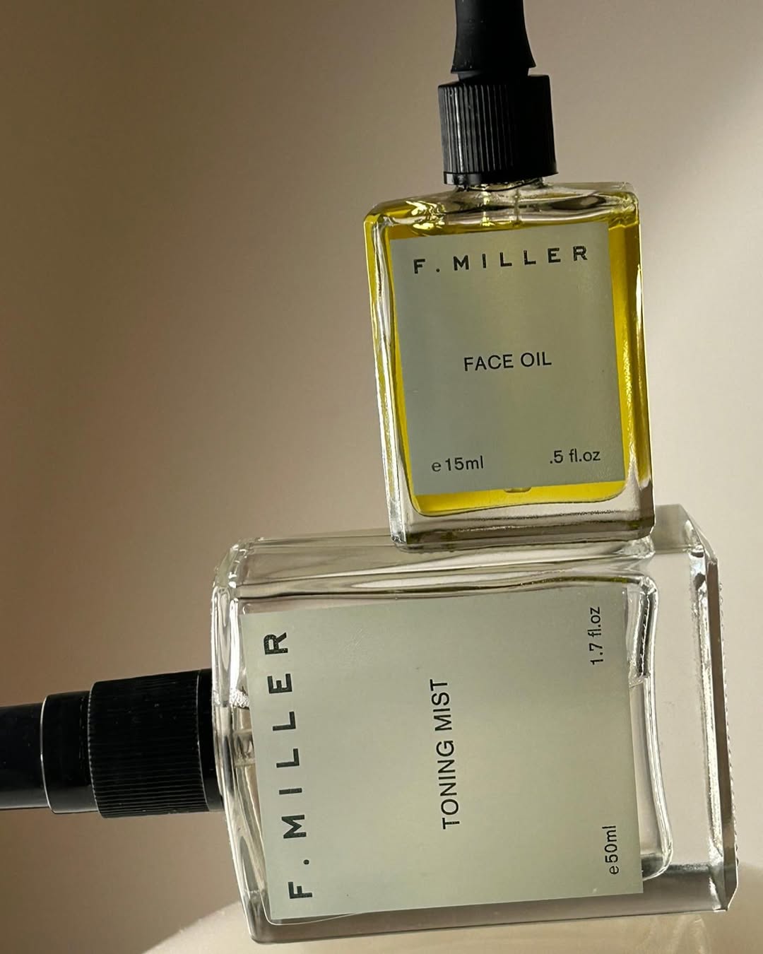 Bottles of F. Miller face oil and toning mist, positioned against a neutral background.