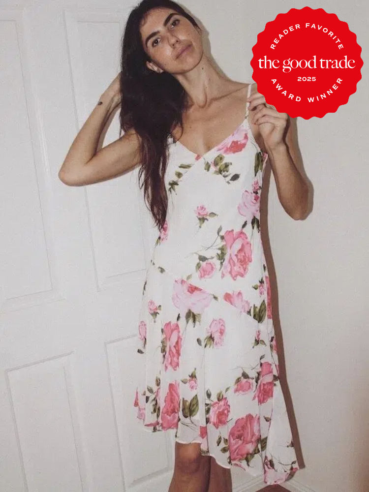 Person posing in a floral dress in front of a white door. There is a red award badge overlay that says "Reader Favorite, the good trade, Award Winner 2025.