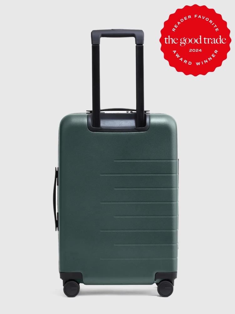 Green hard shell suitcase with extended handle, standing upright on a light gray background, labeled as "reader favorite yard winner 2024.