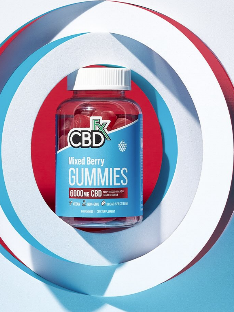 Bottle of mixed berry cbd gummies displayed on a graphic background with concentric circles in shades of blue, red, and white.