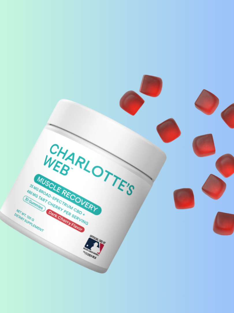 A jar of charlotte's web muscle recovery gummies, with several gummies floating around it, against a pastel gradient background.
