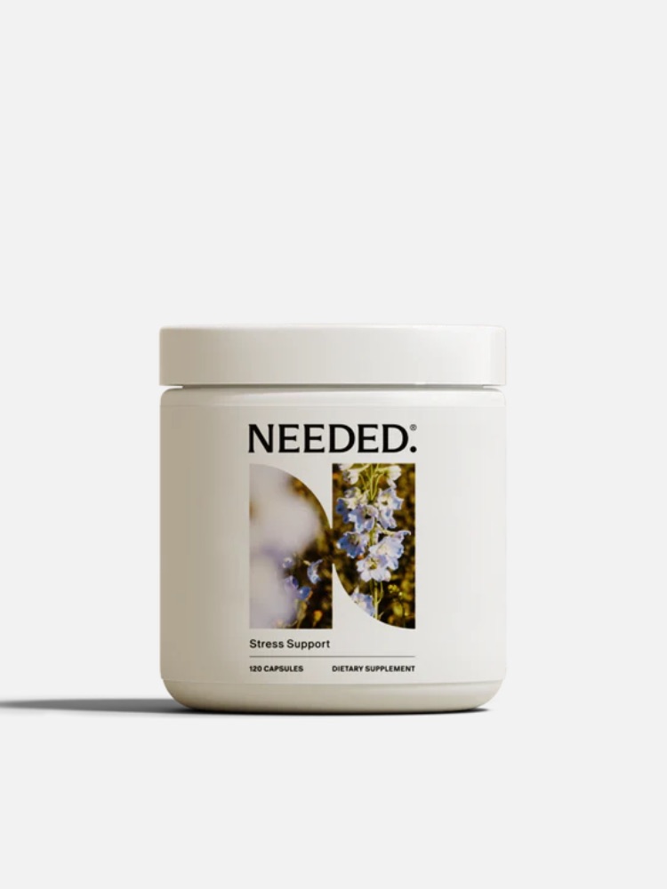 A white container labeled "NEEDED: Stress Support" with an image of white flowers and herbs. The container claims to contain 120 dietary supplement capsules.