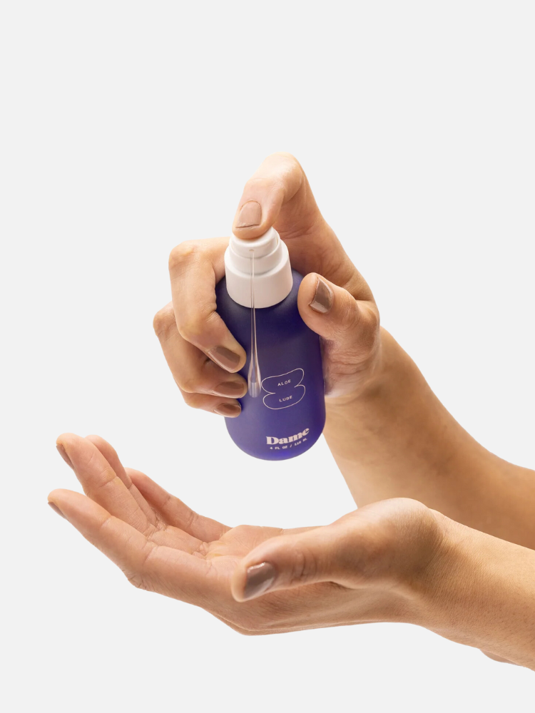 A person is dispensing lotion from a blue bottle labeled "Dame" into their palm.