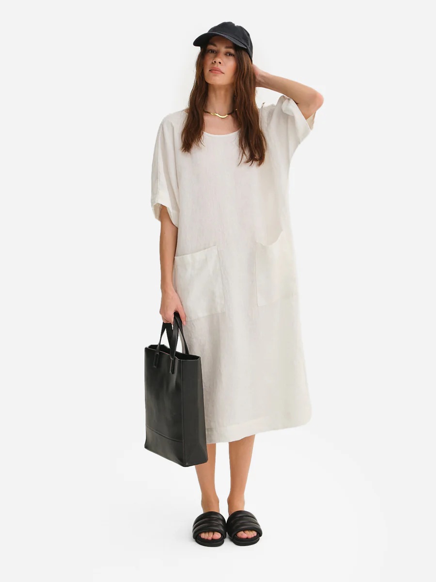 A model wears a cream maxi linen dress from MATE the Label. 