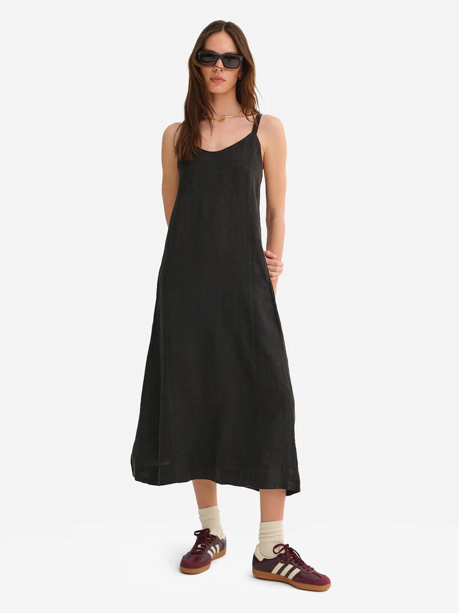 A model wears a black maxi linen dress from MATE the Label. 