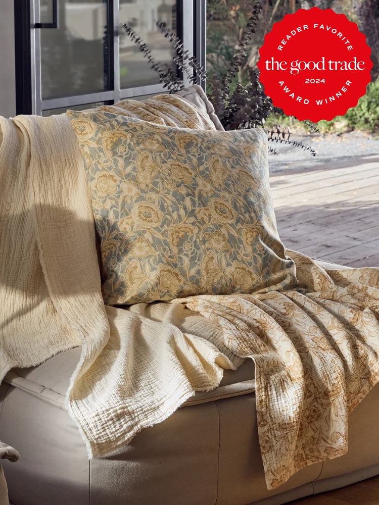 A gold and white floral throw from Coyuchi on a chair. 