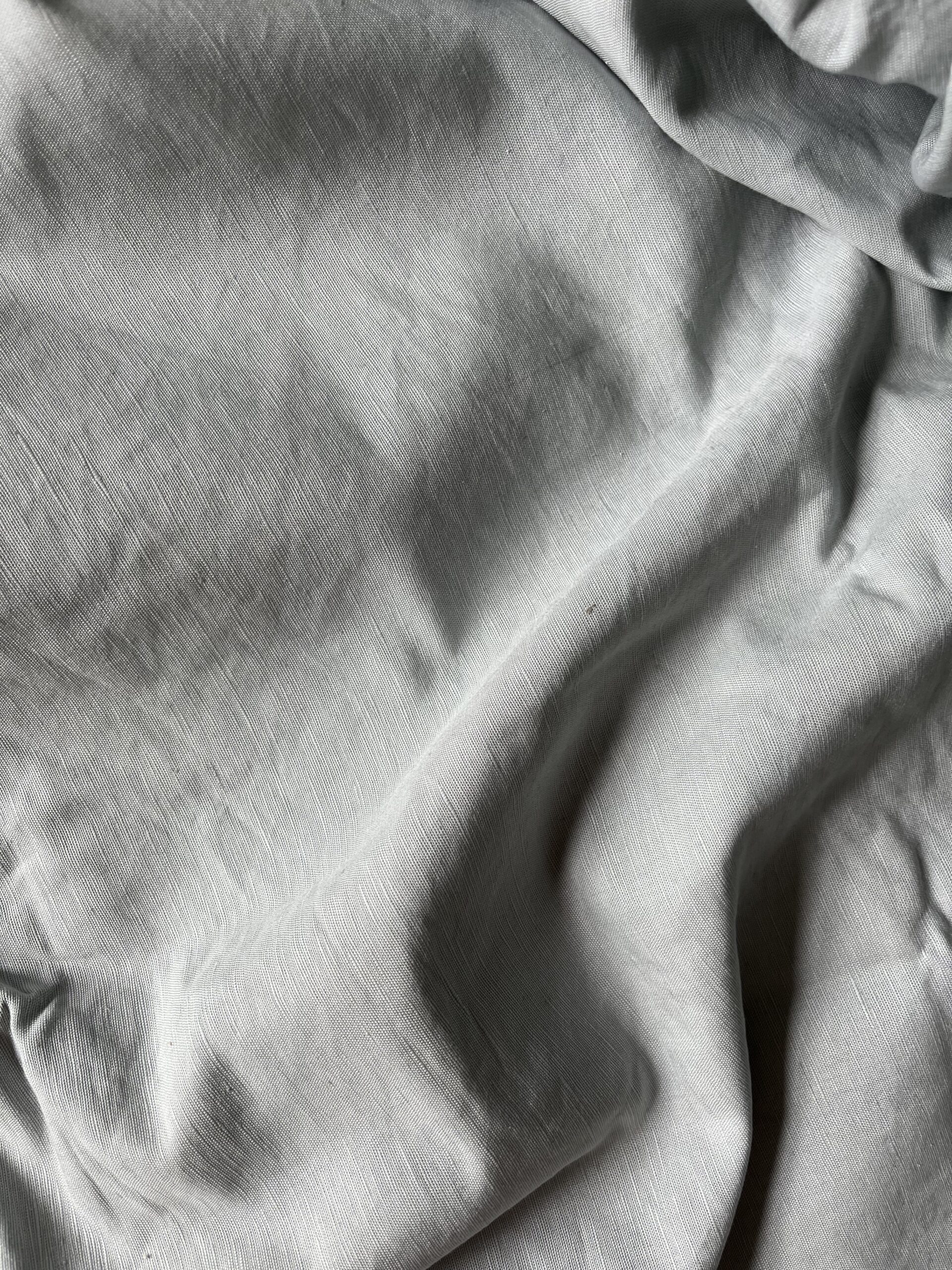 A close-up view of wrinkled, light gray fabric.