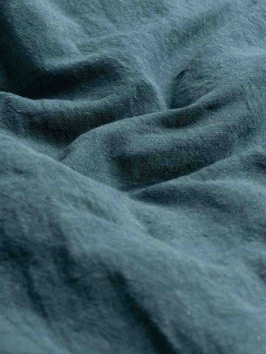 Close-up of a textured dark gray fabric with visible folds and creases.