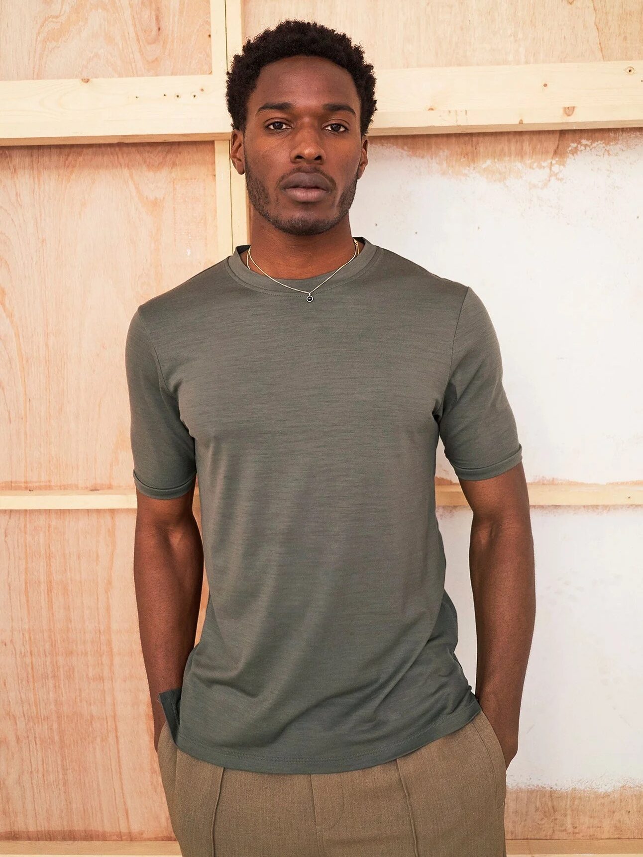 A model wears a green t-shirt from Neem London. 