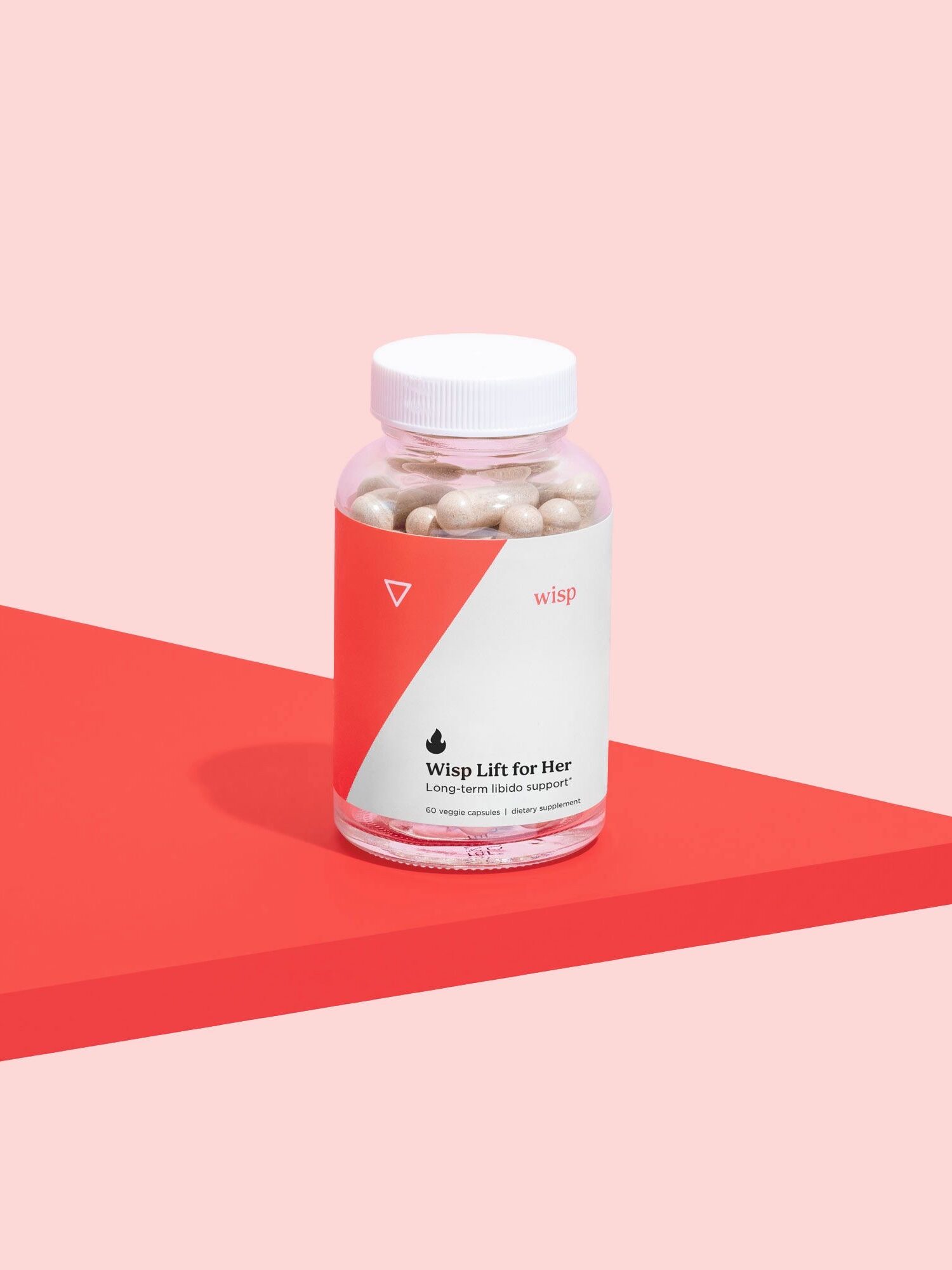 A bottle labeled "Wisp Lift for Her" with beige capsules inside is placed on a red and pink geometric surface.