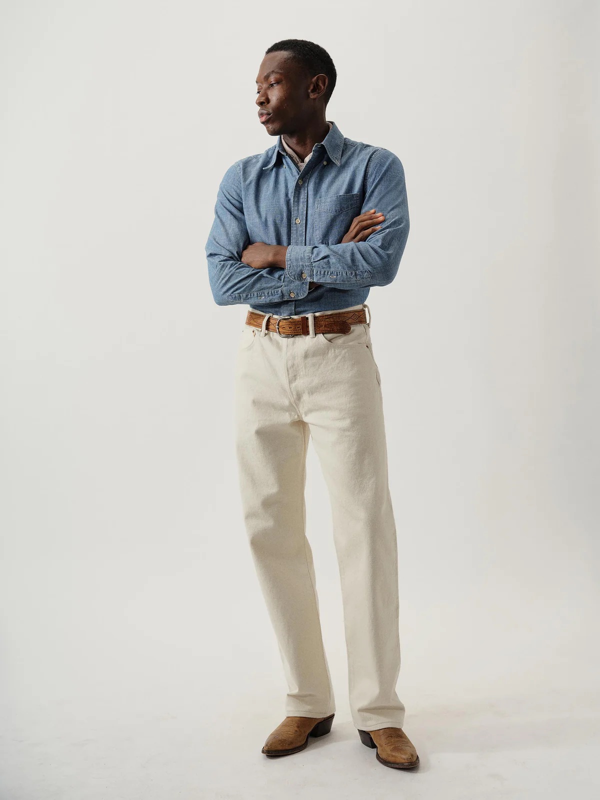 A model wearing white Buck Mason jeans. 