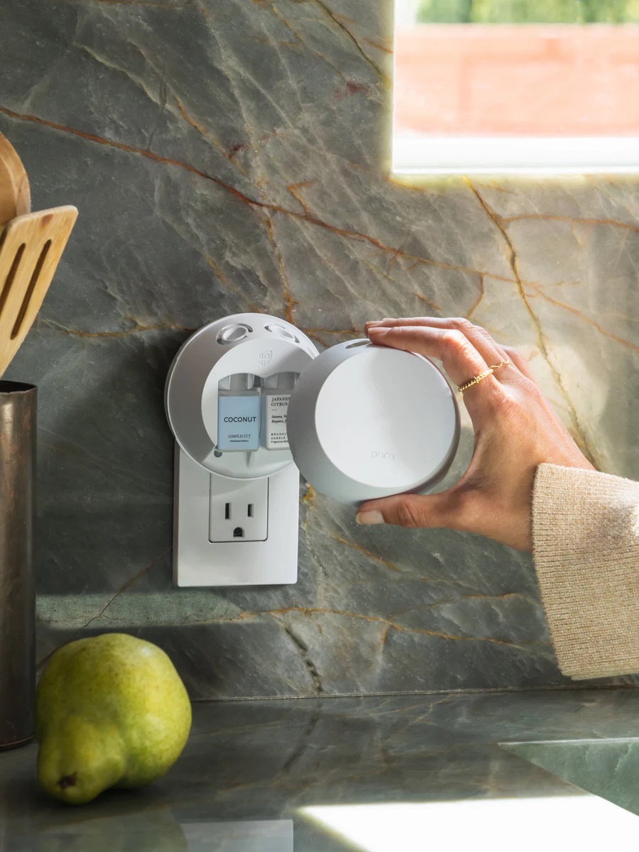 A model adding the cover to a Pura Smart Essential Oil Plug In Diffuser. 