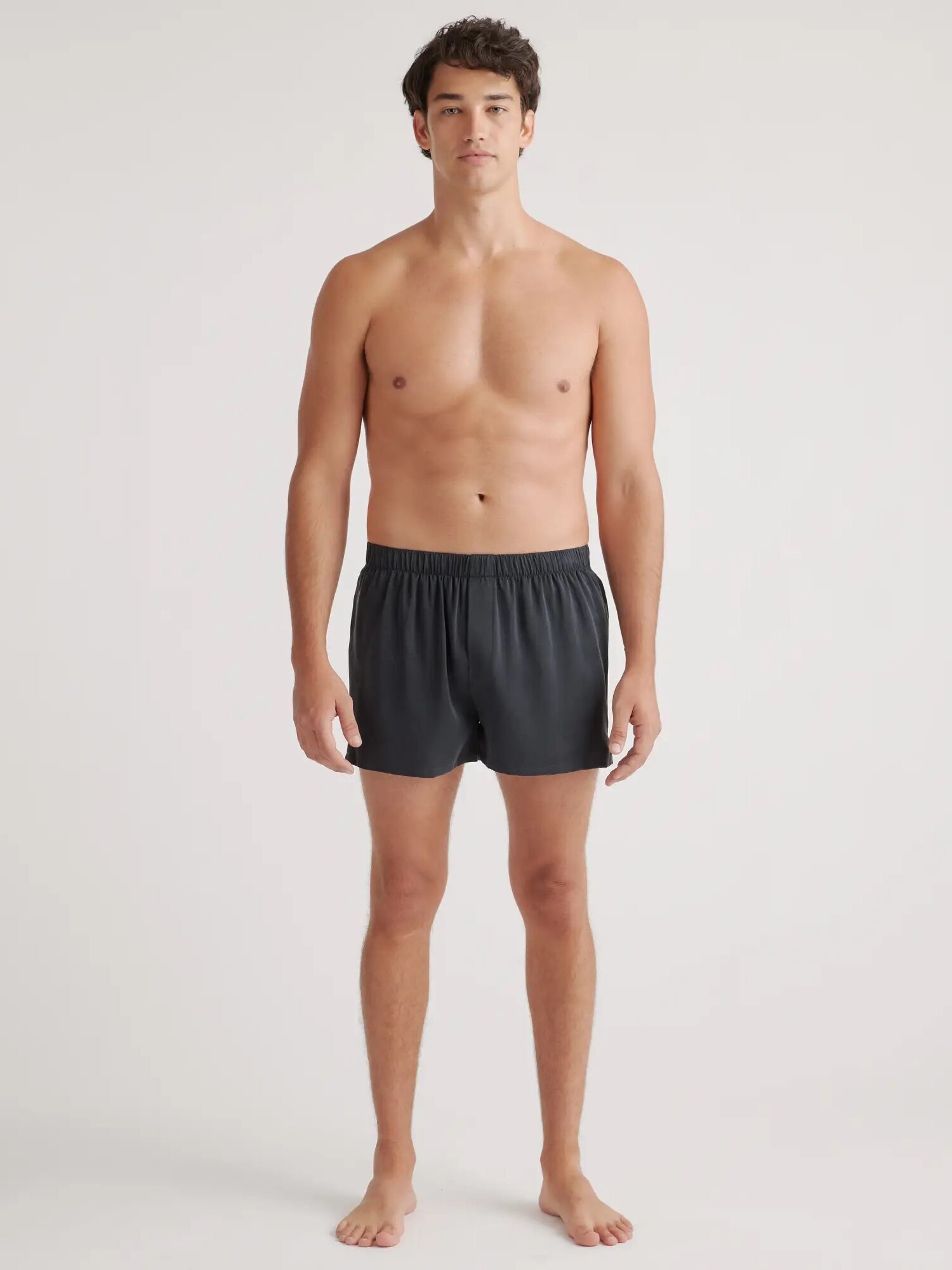 A model wearing black silk boxers from Quince. 