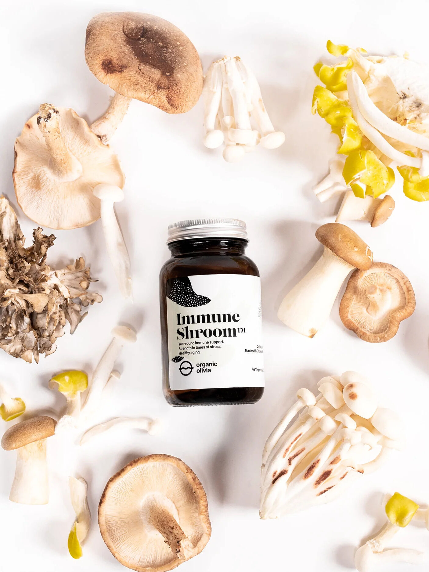 A bottle labeled "Immune Shroom" surrounded by various types of mushrooms on a white background.