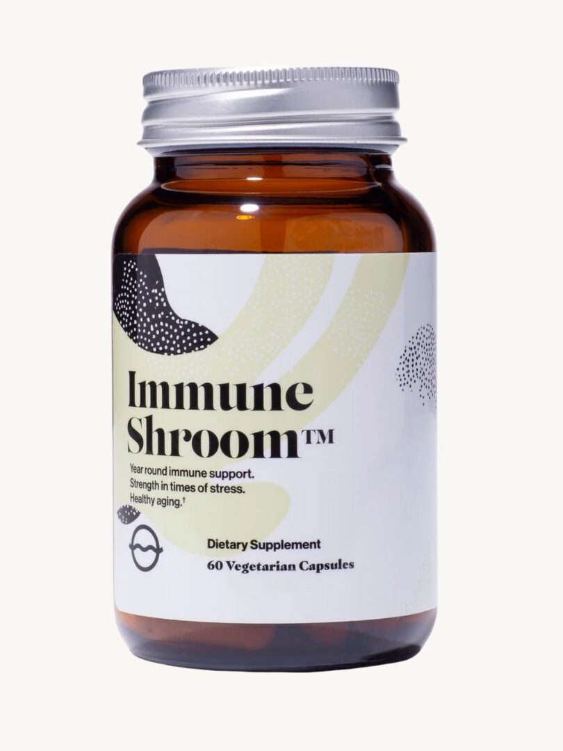 A brown glass bottle labeled "Immune Shroom" contains 60 vegetarian capsules. The label highlights immune support, stress strength, and healthy aging.