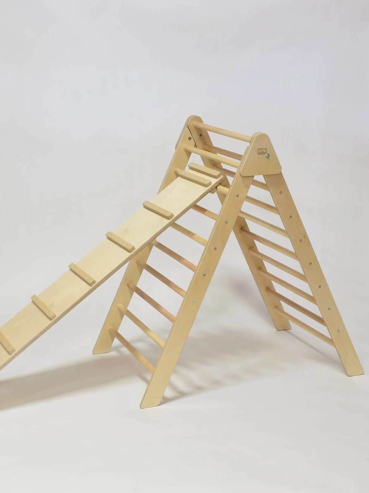 A wooden climbing triangle with an attached ramp is shown against a plain white background.