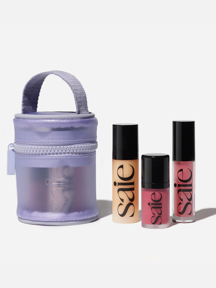 A small set of three Saie makeup products with a purple zipper pouch.