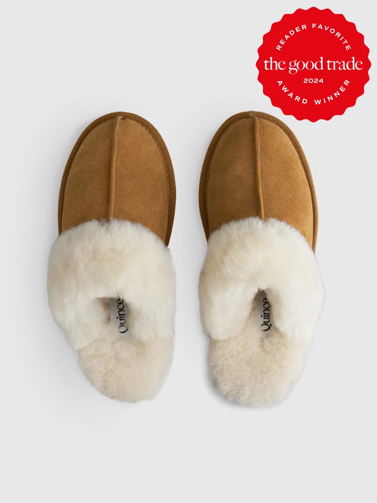 A pair of tan indoor slippers with white fluffy lining, displayed on a white background. An award badge in the top right corner reads "Reader Favorite - the good trade 2024 - Award Winner.