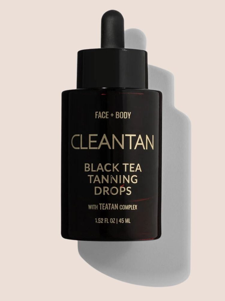 A black bottle of Cleantan Black Tea Tanning Drops for face and body with a dropper cap and 45 mL capacity on a light beige background.