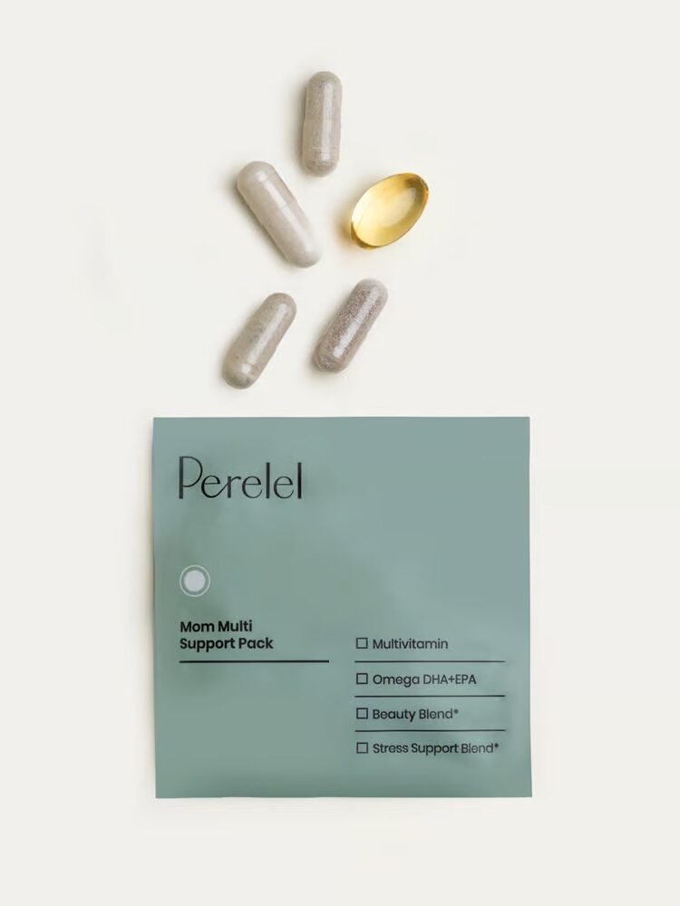 A gray packet labeled "Perelel Mom Multi Support Pack" lies on a white background. Four gray capsules and one yellow oblong capsule are scattered above the packet.