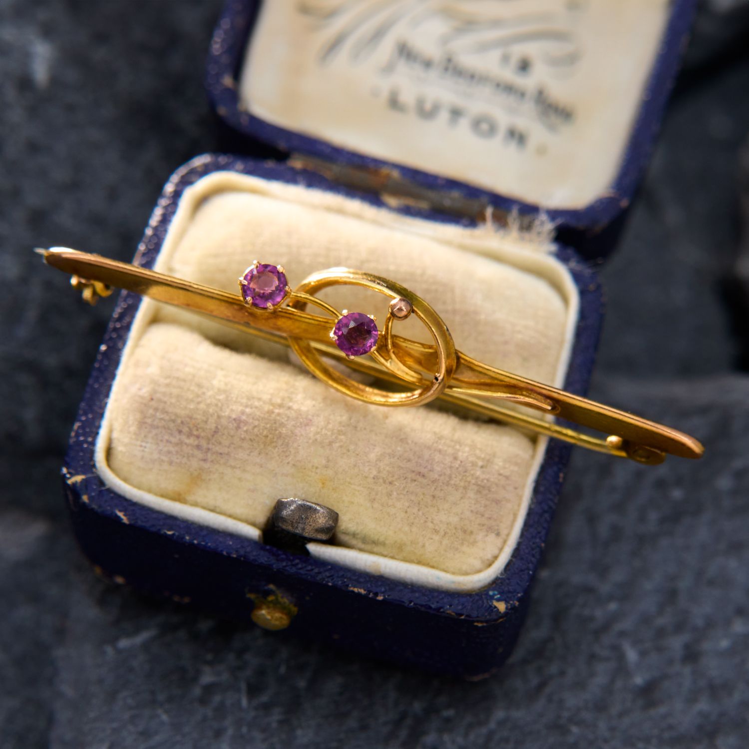 A vintage gold and purple gemstone brooch. 