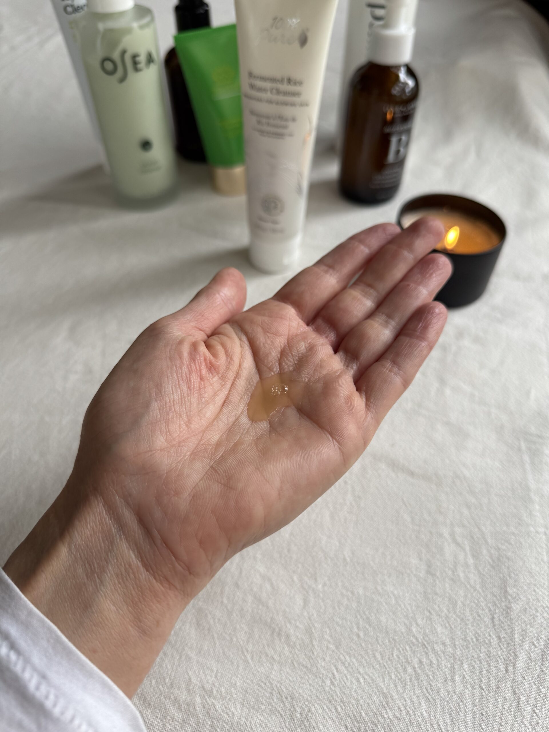 A hand with a small amount of 100% Pure face wash in the palm.