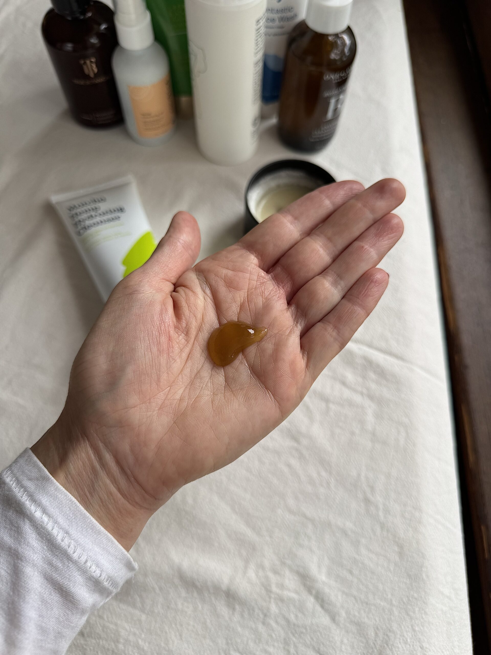 A hand with a small amount of KRAVEBEAUTY face wash in the palm.