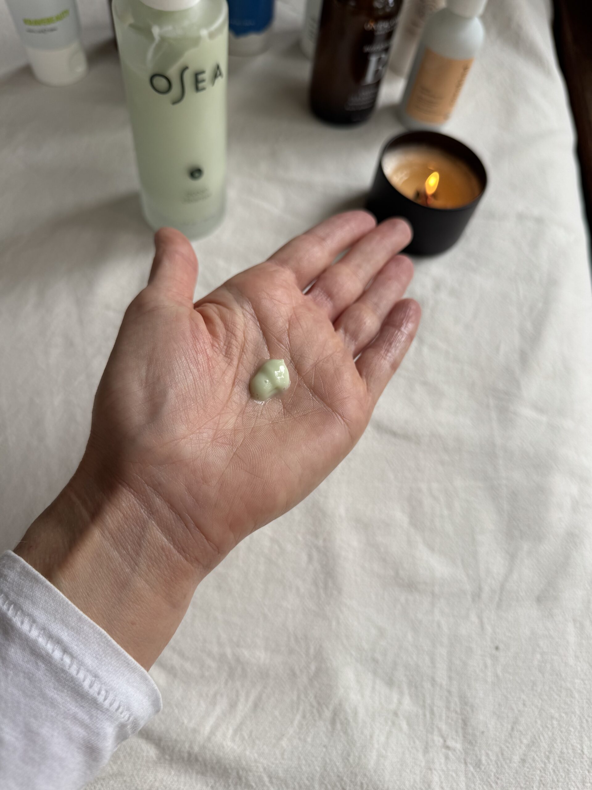 A hand with a small amount of OSEA face wash in the palm.