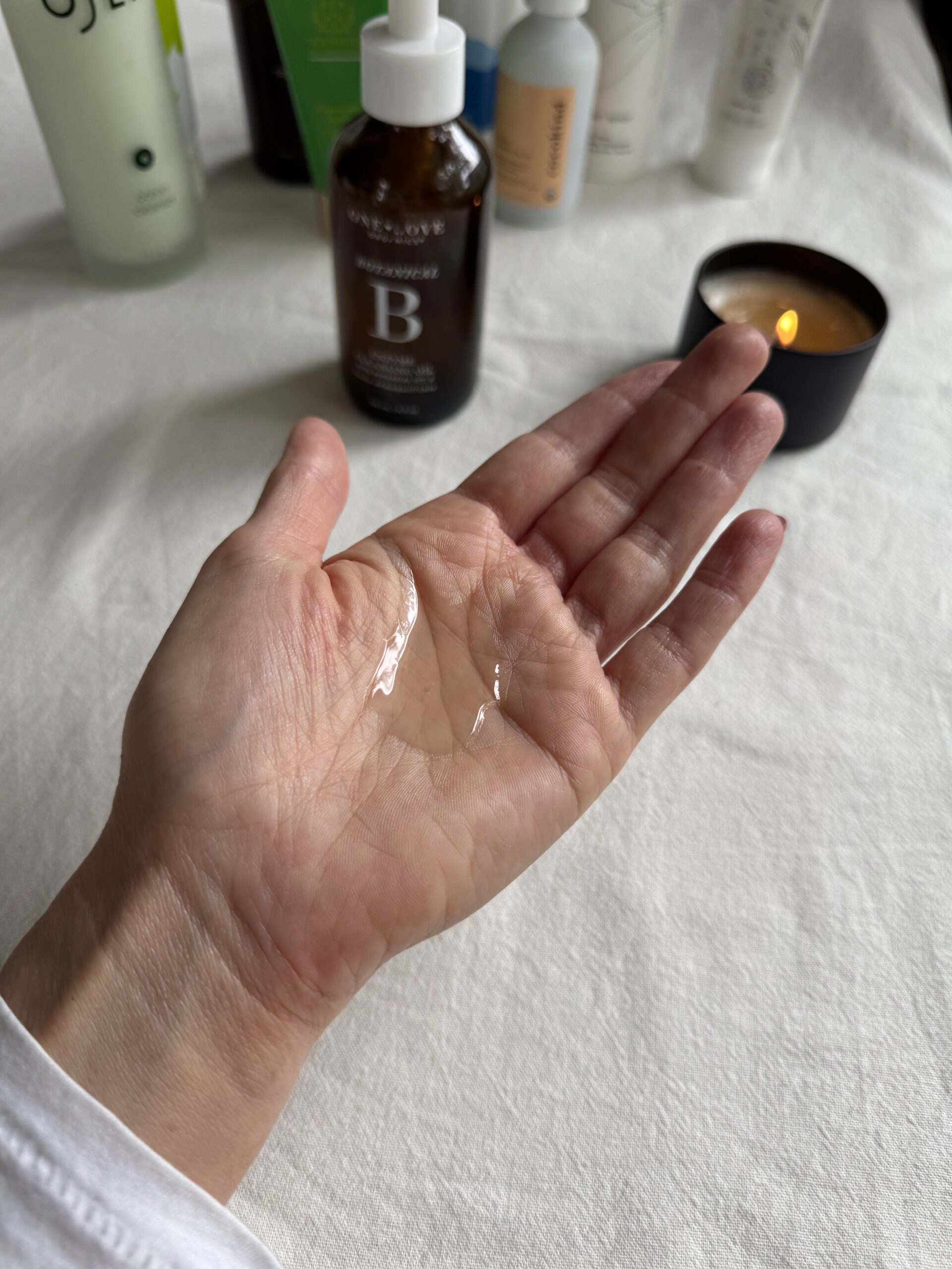 A hand with a small amount of One Love Organics face wash in the palm.