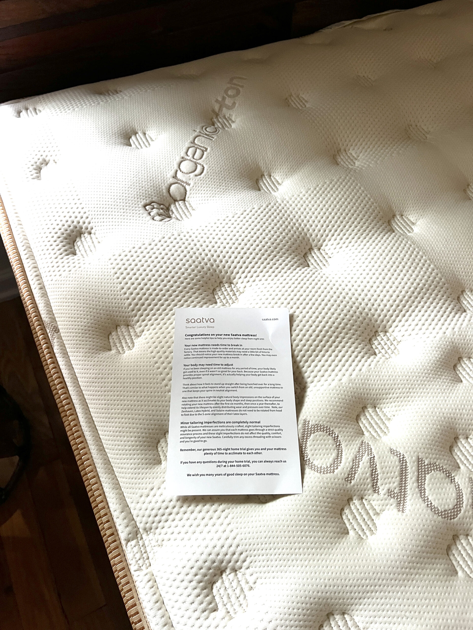 A new Saatva mattress is in the background labeled "Organic Cotton" and in the foreground are instructions and information for setting up a new Saatva mattress.