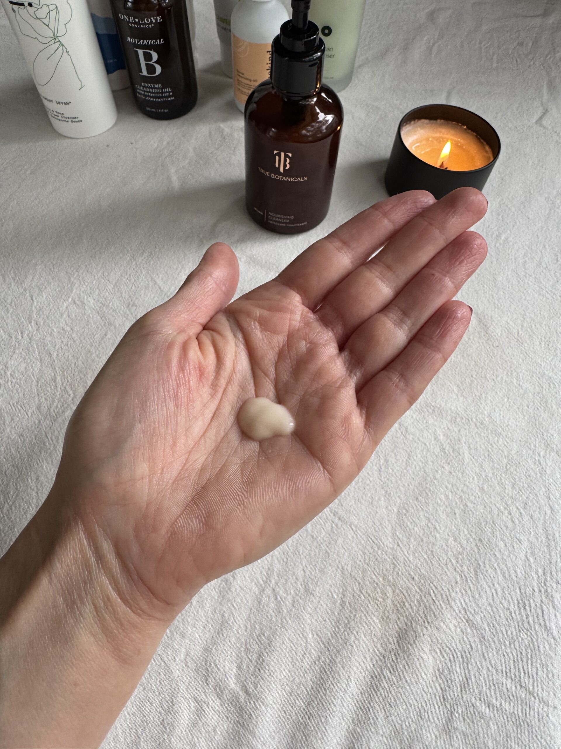 A hand with a small amount of True Botanicals face wash in the palm.