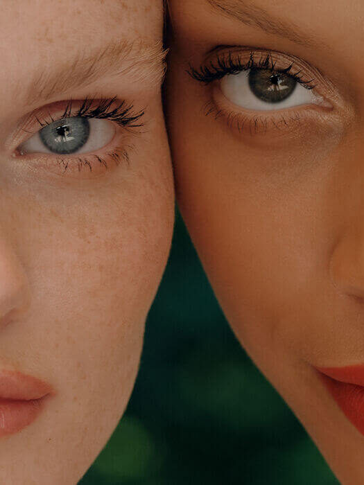 Close-up of two women's faces, side by side, showing different skin tones, eye colors, and makeup styles.