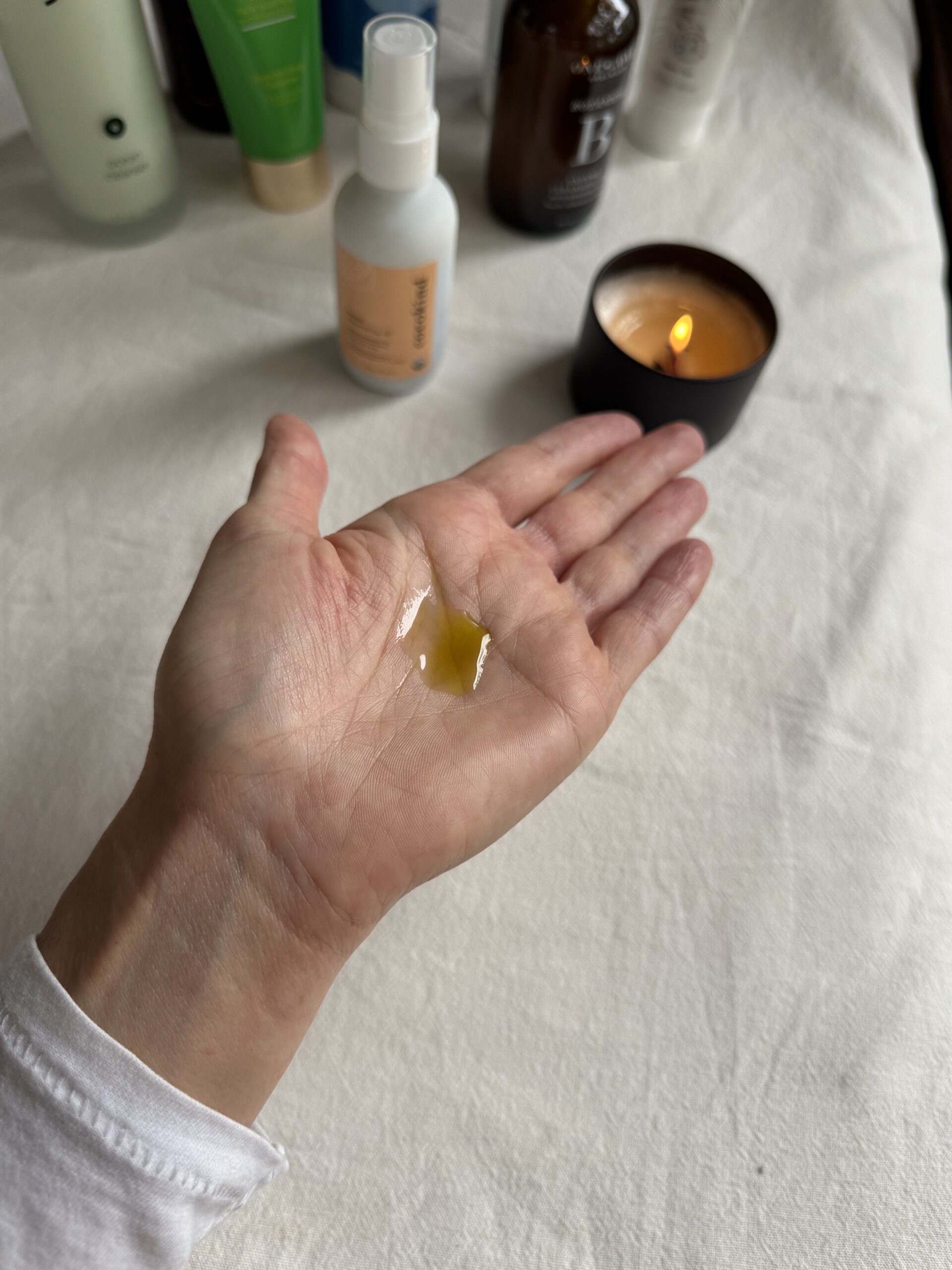 A hand with a small amount of cocokind facial cleansing oil in the palm.