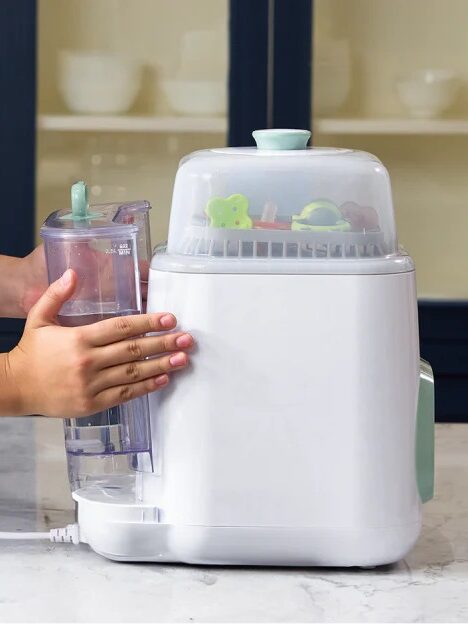 Person using a white countertop kitchen appliance with a clear water tank.