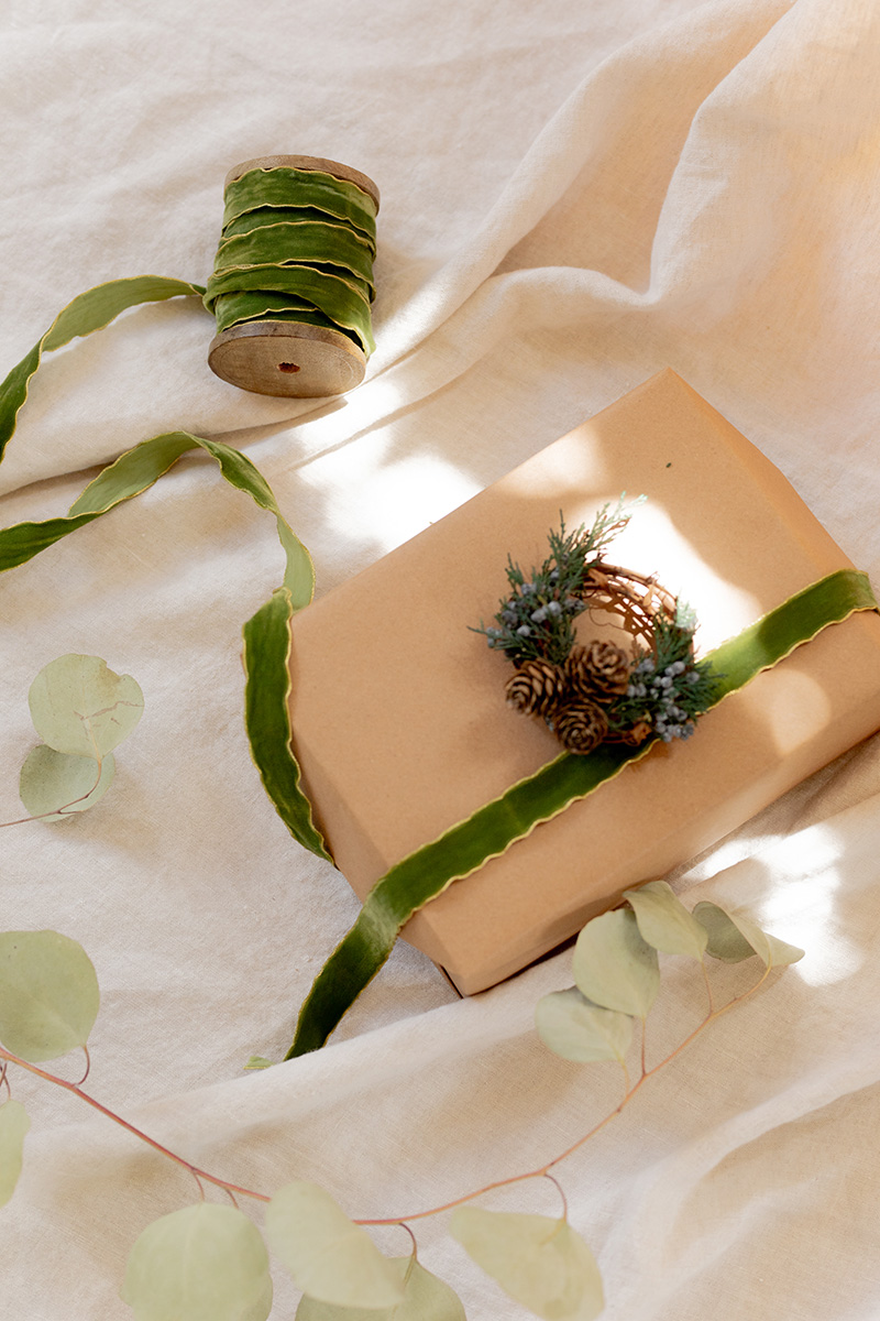 A wrapped up gift next to a roll of ribbon.