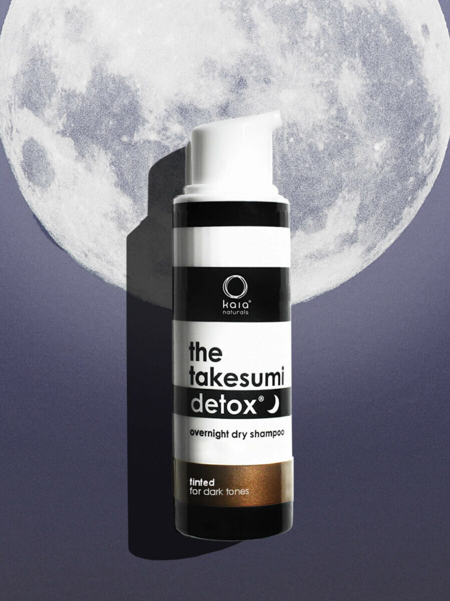 A bottle of "the takesumi detox overnight dry shampoo" for dark tones, positioned against a background featuring a large full moon.