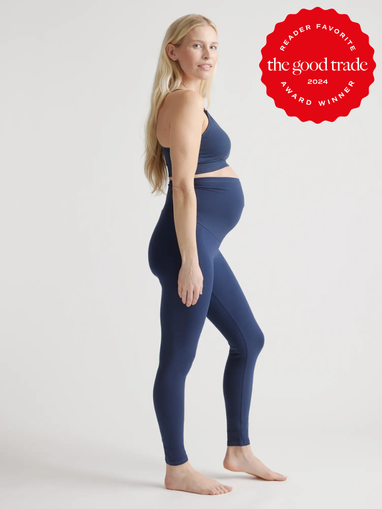 Pregnant woman wearing blue leggings and a sports bra, standing sideways. A badge on the image reads "Reader Favorite - The Good Trade Award Winner 2024.