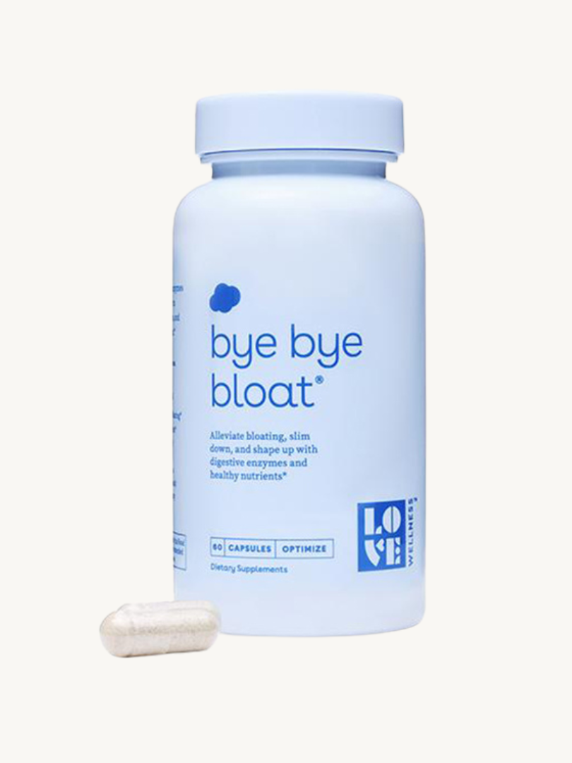 A blue bottle labeled "bye bye bloat" next to a single white capsule. The supplement is designed to alleviate bloating, slim down, and shape up using digestive enzymes and nutrients.