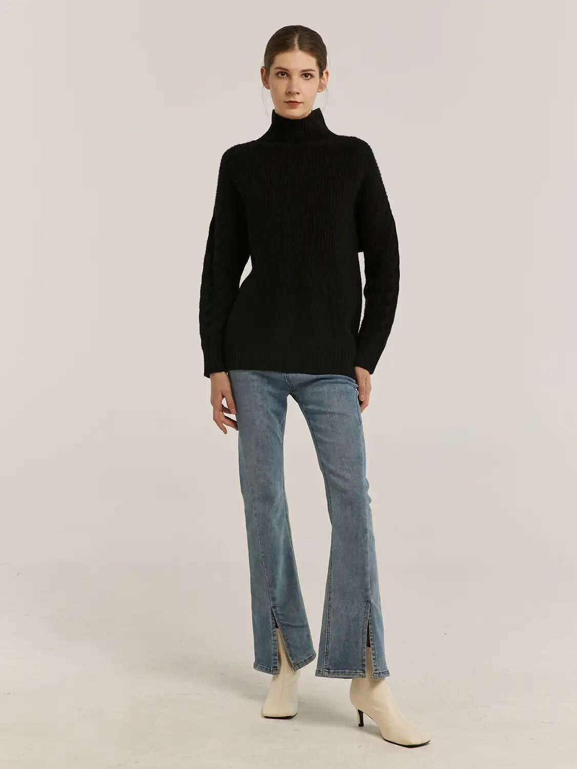 A model wearing a black cashmere turtleneck from Gentle Herd. 