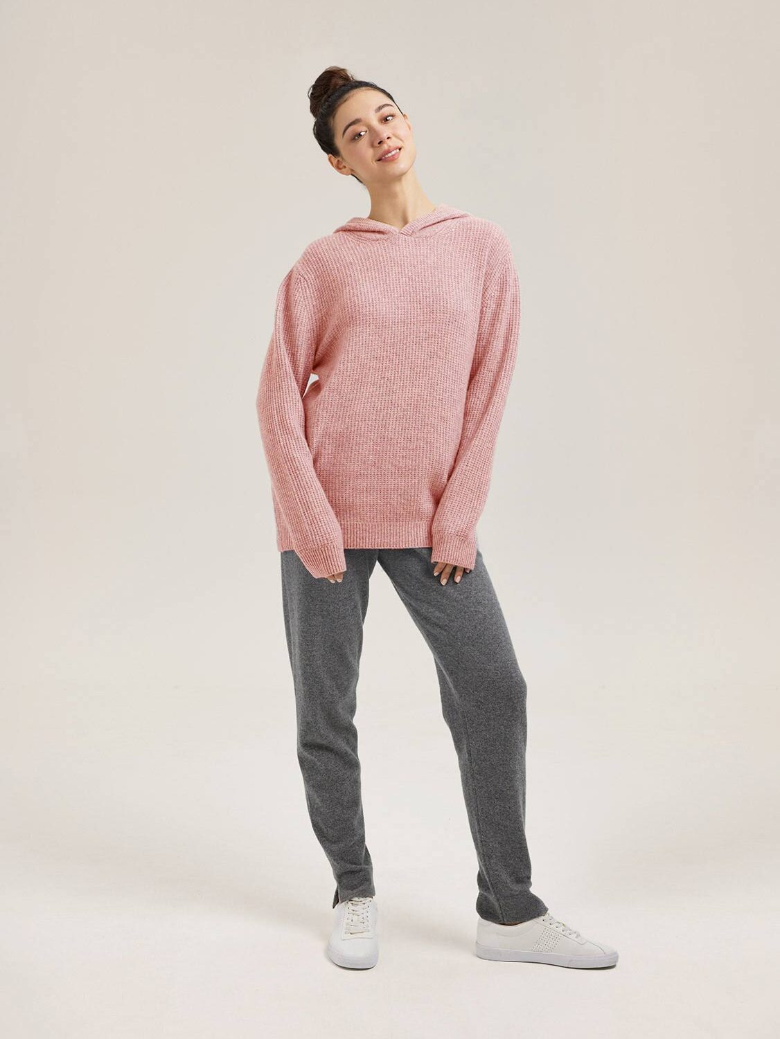 A model wearing a pink cashmere hoodie from Gentle Herd. 