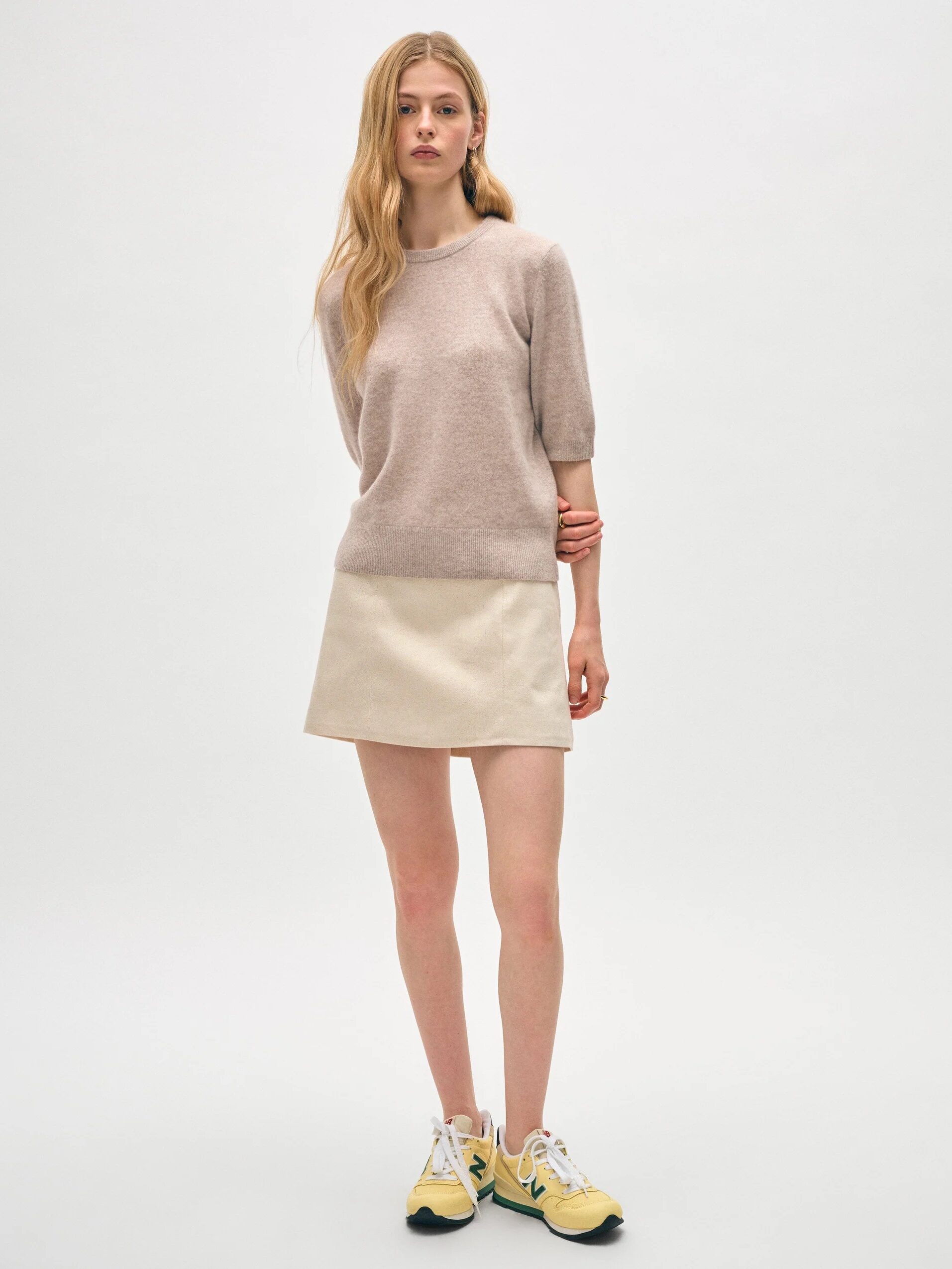 A model wearing a beige 3/4 sleeve length cashmere sweater from White & Warren. 