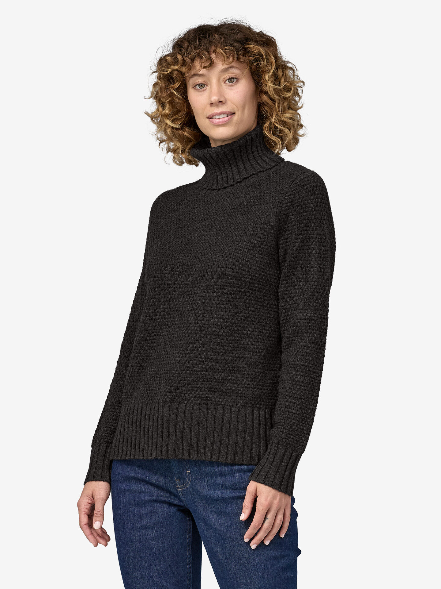 A model wearing a black cashmere turtleneck from Patagonia.