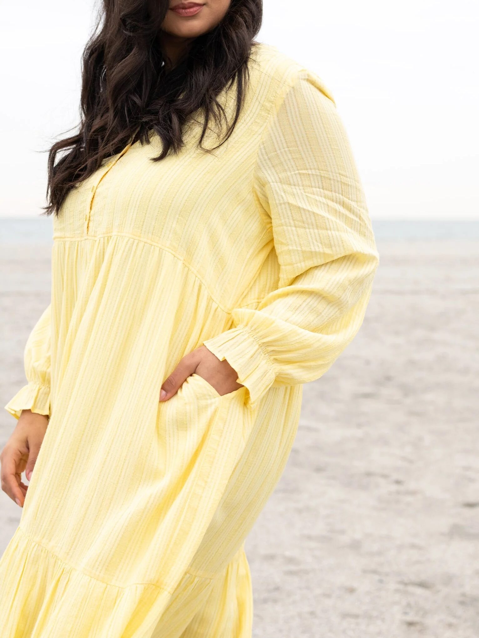 A model wearing a yellow maxi house dress from Able. 