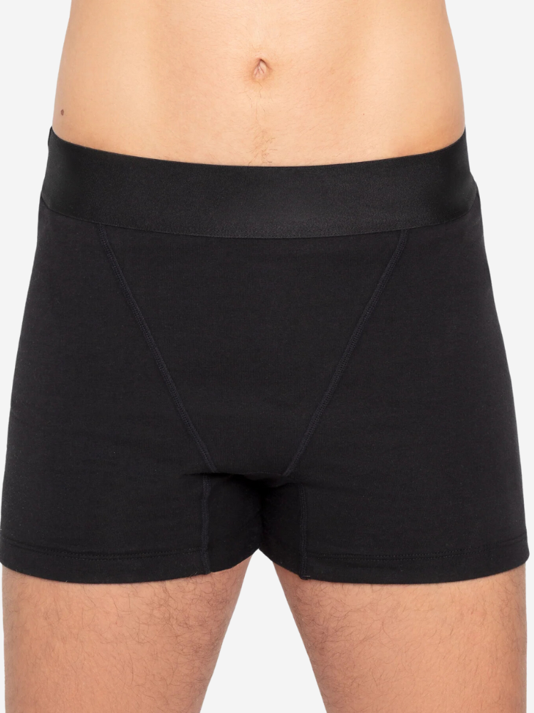 Close up of a model wearing black period boxer shorts from The Period Company. 