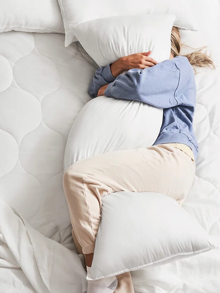 A model snuggling with a Buffy pillow. 