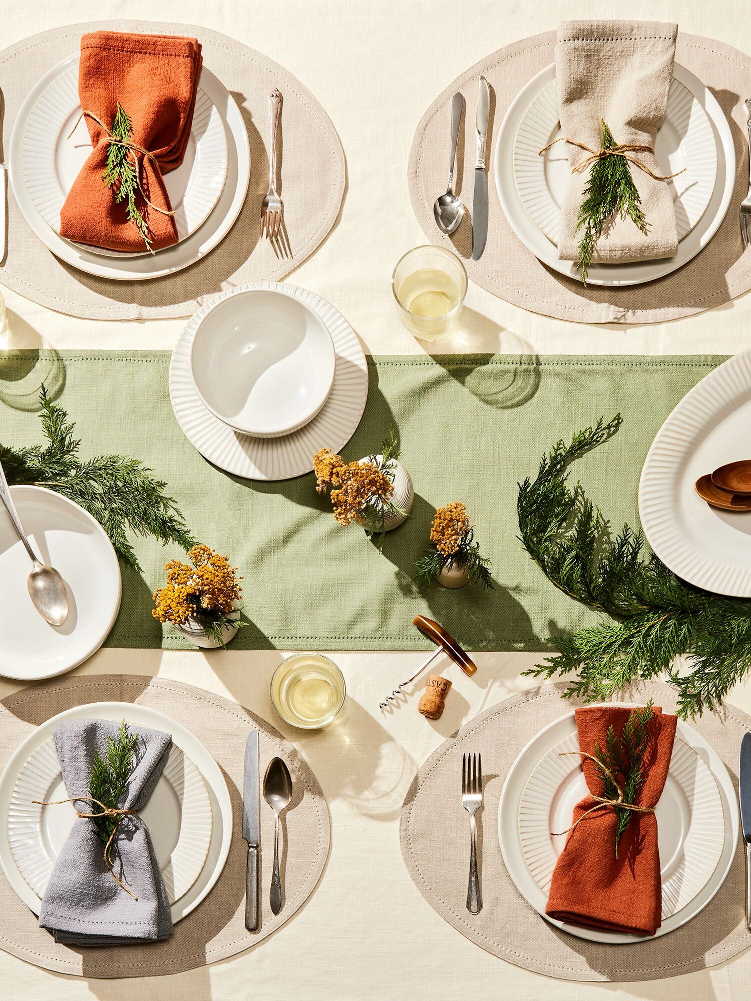 A table set up with a green table runner down the center. 