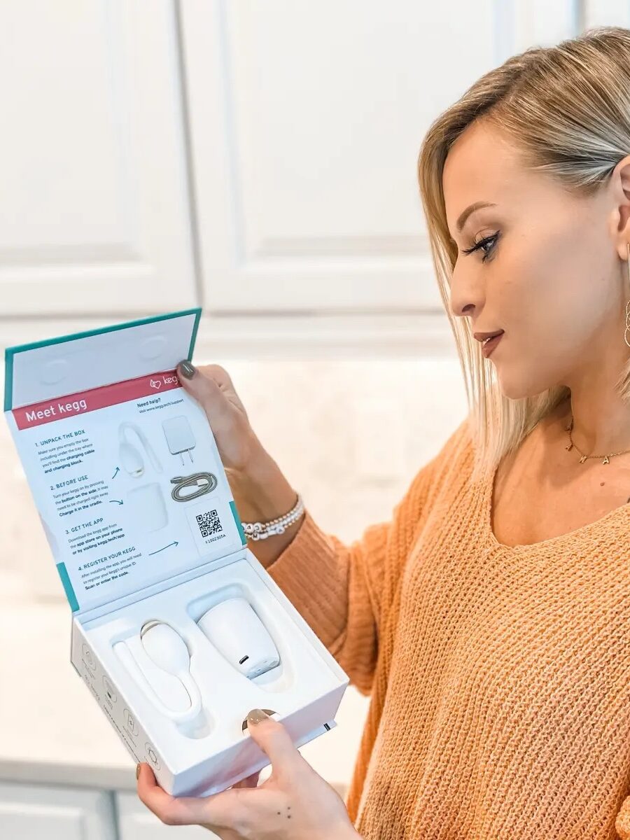 A women's opens the packaging of a keg cervical mucus tracker. 