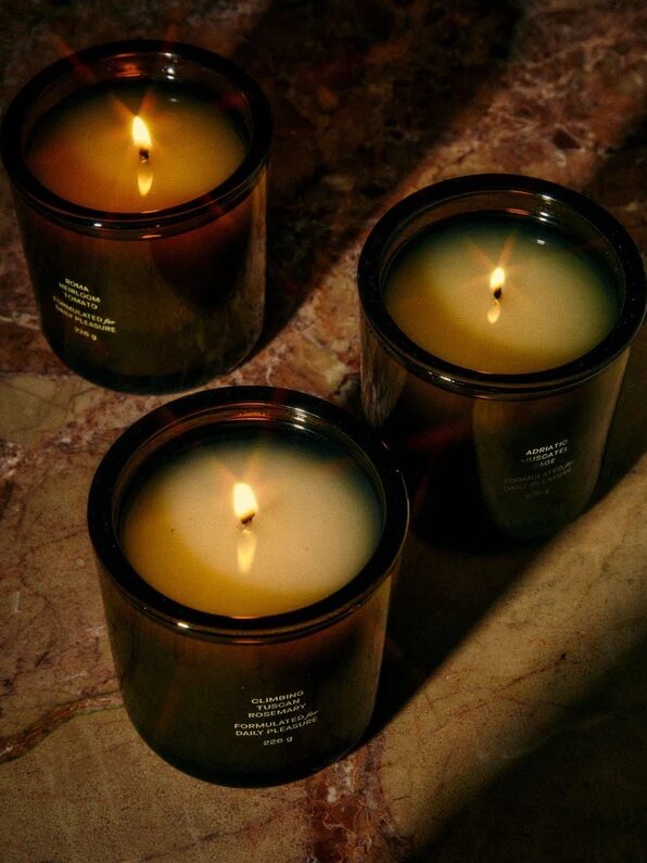 Three Flamingo Estate candles set on a table. 