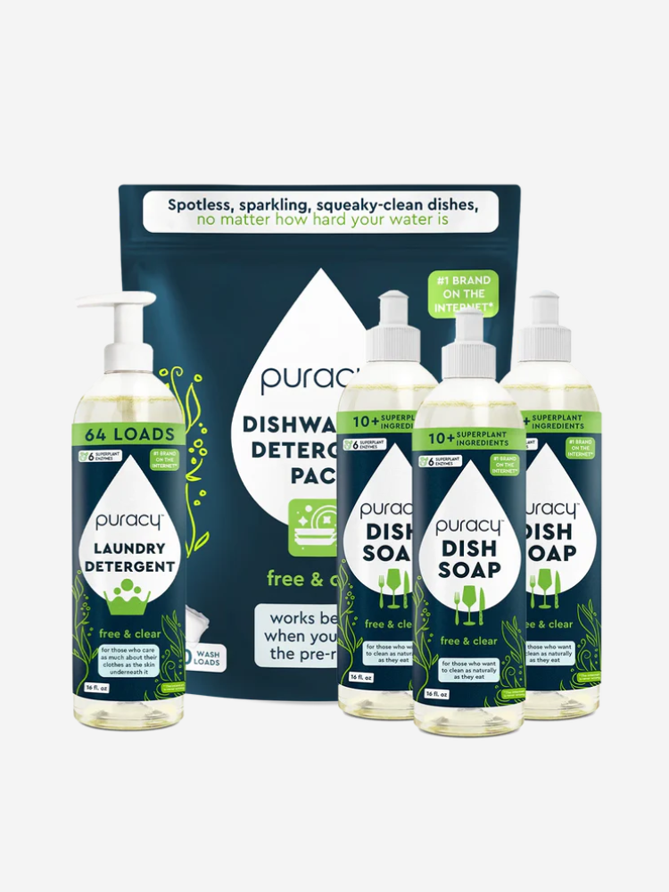 Puracy cleaning products, including laundry detergent, dish soap, and dishwasher detergent packs, are arranged together. Packaging emphasizes natural ingredients and eco-friendly labeling.