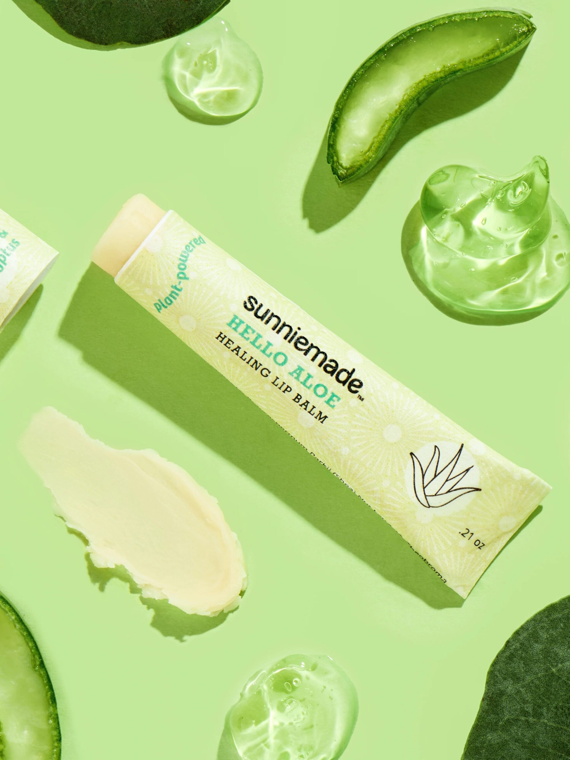 A Sunniemade lip balm surrounded by aloe vera. 